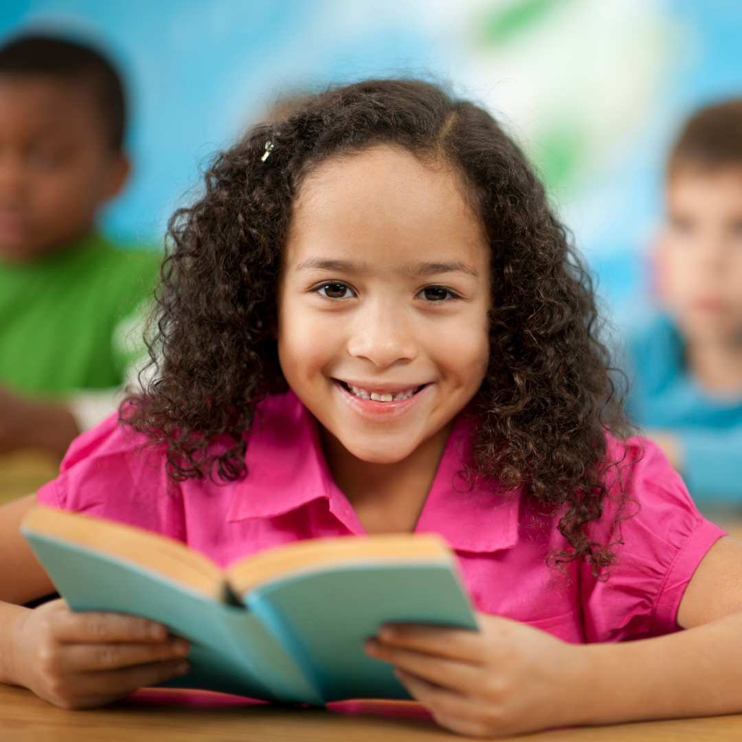 smiling elementary school child reading